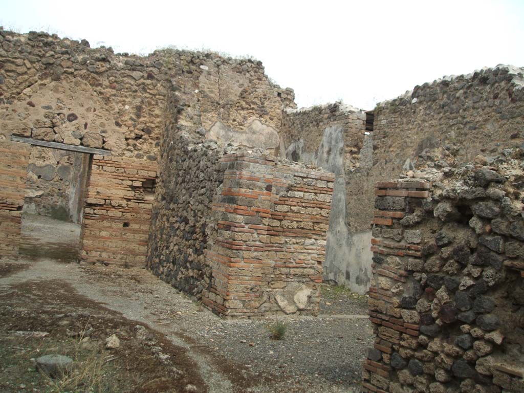 IX.5.16 Pompeii. May 2005. Looking north-east across atrium a’, with ala c’ and triclinium d’ on the right.
The doorway on the left, in the north wall of the atrium leads into room “i” of IX.5.14.