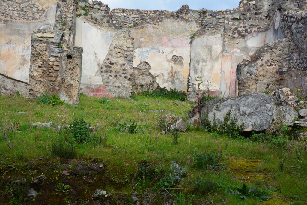 IX.5.18 Pompeii. March 2017. Room “b”, looking north-east across atrium/courtyard garden area.
Foto Christian Beck, ERC Grant 681269 DÉCOR.
According to PPM –
Courtyard (b):
The north portico was supported by a pillar on which a semi-column was leaning, of which the remains can be glimpsed (to the left of photo), and by a pillar covered in white stucco (now fallen over, on right) and subsequently connected by a low wall, painted with plants on the external façade, which enclosed the viridarium area in the centre of which was the basin/pool with a central fountain.
See Carratelli, G. P., 1990-2003. Pompei: Pitture e Mosaici. IX.(9).Roma: Istituto della enciclopedia italiana, (p.675).