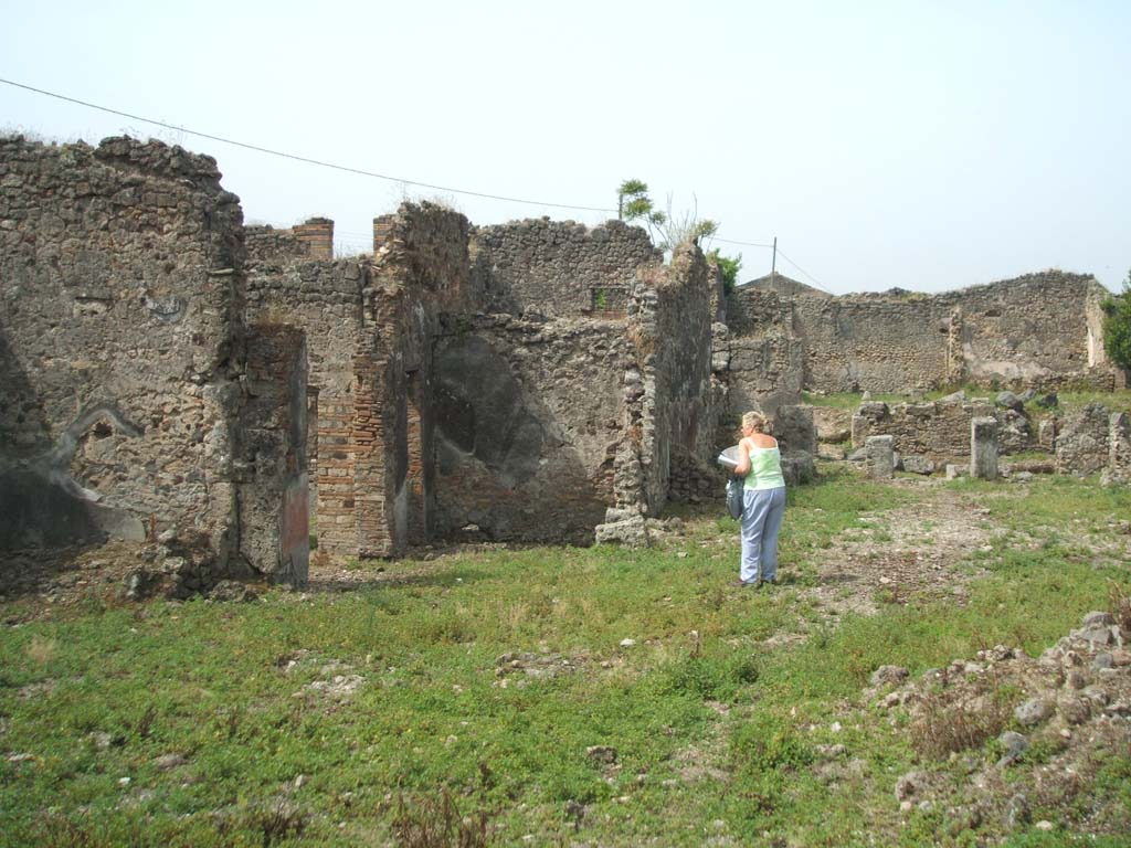 IX.6.4, IX.6.3 and IX.6.g Pompeii. May 2005. Looking west from IX.6.g.
South-east corner of kitchen area of IX.6.4, approximately where the figure is standing.