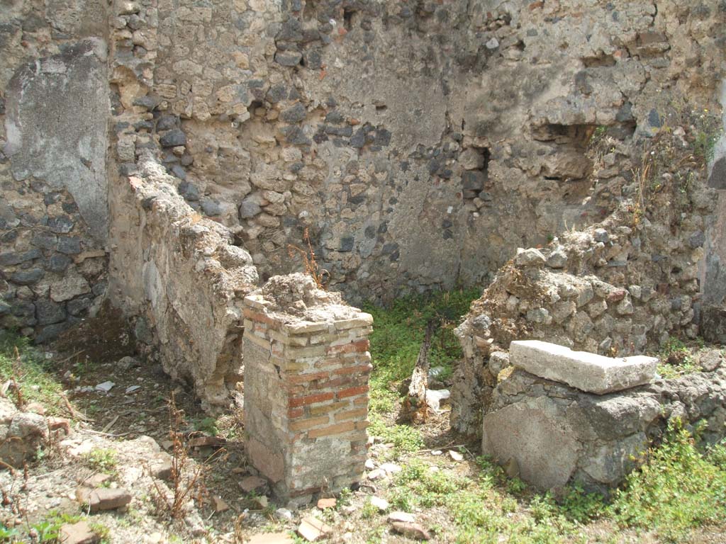 IX.6.7 Pompeii. May 2005. Looking south-east to two rooms on east side of entrance.
These would have been a latrine room “q” on left, and small room or storeroom room “r”, on right.
The remains of the tub/basin can be seen on the right of the photo.
