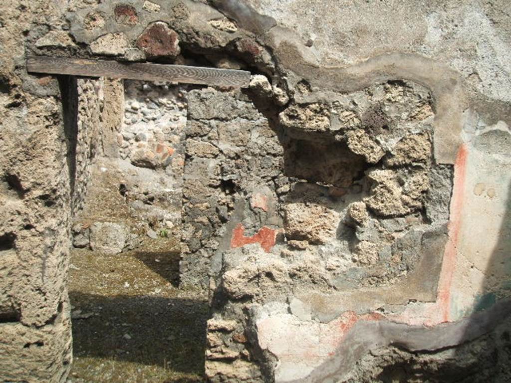 IX.6.d Pompeii. May 2005. 
Looking towards north wall of “d”, and through doorway to two rear rooms “f”and “g”. 
On the pilaster, on the left of this photo, a wall painting of a herm of Hercules was found, on a black background.
Nearby was graffiti, a Greek inscription with names of the divinities – (CIL IV 5202).
See Schefold, K., 1957. Die Wande Pompejis. Berlin: De Gruyter. (p.266)
See Sogliano, A., 1879. Le pitture murali campane scoverte negli anni 1867-79. Napoli: (p.78, nos.492)