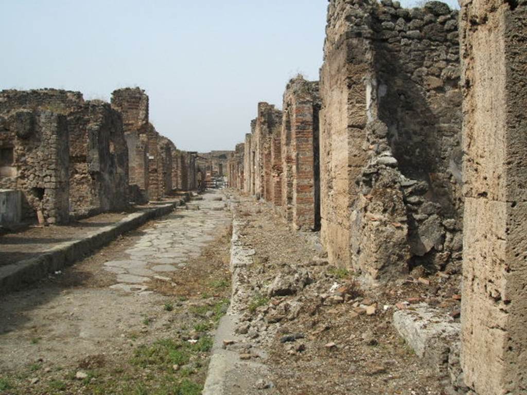 IX.7 Pompeii. May 2005. Unnamed vicolo, looking west.                     IX.6.f, on the right.
According to Mau, at the pilaster (made of blocks of Sarno stone) between it and number 10, a piece of wall 1,30 long in Opus incertum was added.