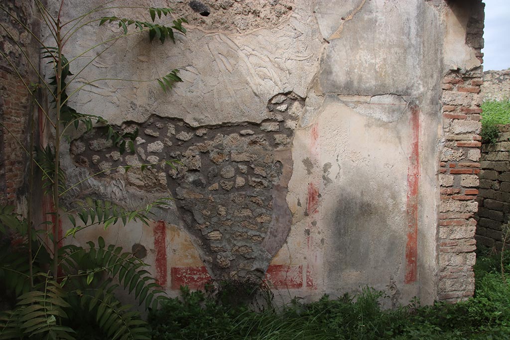 IX.7.16 Pompeii. October 2024. Room “b”, north wall, with doorway to atrium, on right. Photo courtesy of Klaus Heese.
According to PPM –
“The middle zone of the north wall showed, in the centre an aedicula with a yellow background but the central painting had been destroyed by a hole made in antiquity, and narrow red vertical bands which separated it from the black side panels.”
See Carratelli, G. P., 1990-2003. Pompei: Pitture e Mosaici. IX (9). Roma: Istituto della enciclopedia italiana, p. 793.