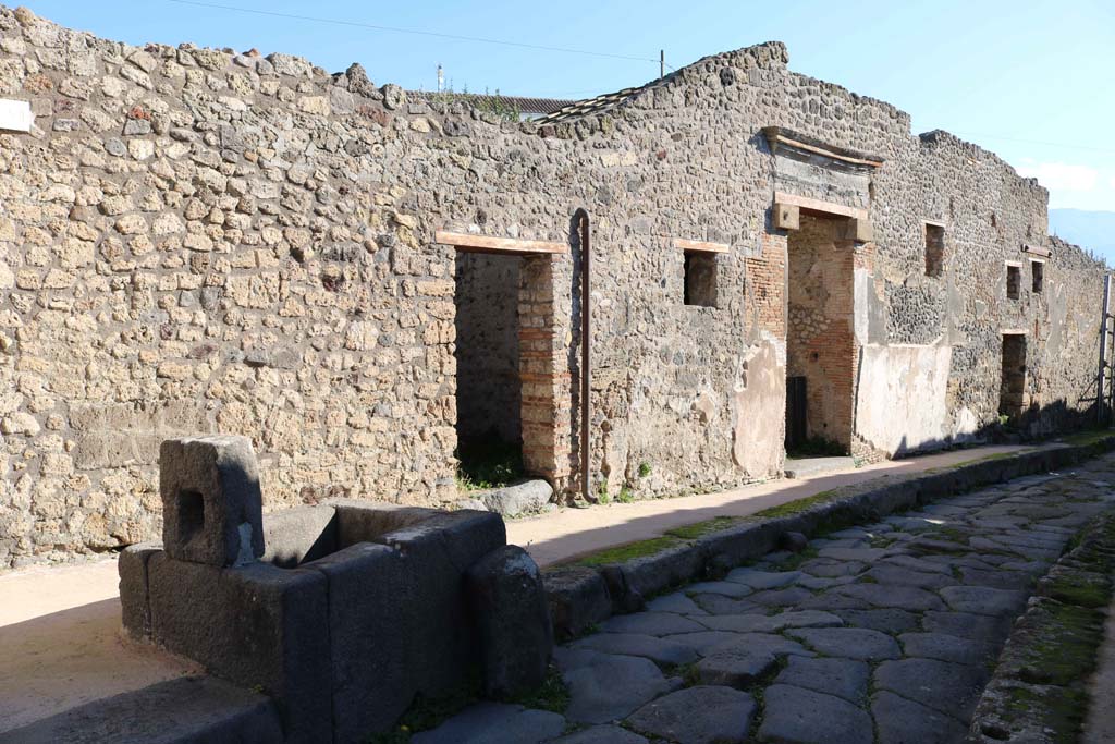 IX.7.17 Pompeii right of fountain, then IX.7.16 and IX.7.15, on right. December 2018. 
Looking south along east side of Vicolo di Tesmo. Photo courtesy of Aude Durand.