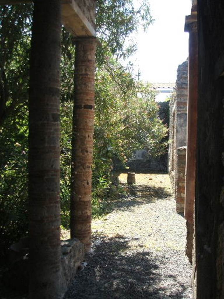 IX.7.20 Pompeii. May 2005. Looking south along west portico. The two columns at the rear of the atrium, leading into the peristyle can be seen on the right.