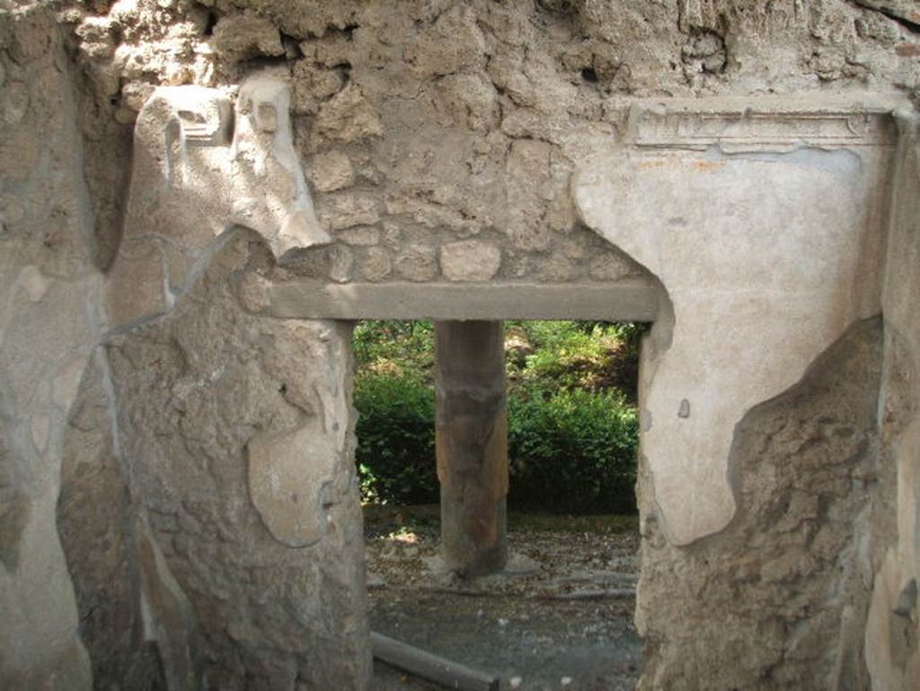 IX.7.20 Pompeii from IX.7.25. May 2005. 
Looking west into peristyle from small room (L) on east side of peristyle.
According to Schefold, found in this room were three wall paintings.
They were Dionysus finding Ariadne, Poseidon and Amymone, and Ariadne giving Theseus a ball of thread. 
See Schefold, K., 1962. Vergessenes Pompeji. Bern: Francke. (He described it as “room l”) p.173 and Taf. I77, nos I. 2. 4 
See Eschebach, L., 1993. Gebäudeverzeichnis und Stadtplan der antiken Stadt Pompeji. Köln: Böhlau. (p.434)
See Bragantini, de Vos, Badoni, 1986. Pitture e Pavimenti di Pompei, Parte 3. Rome: ICCD. (p.506-7, cubiculum room L)
See Mau, A: BdI 1883, (p.71-75)