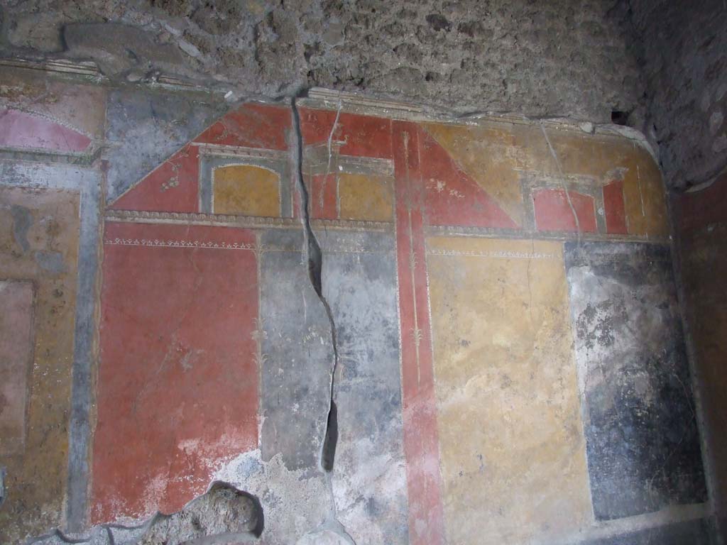 IX.7.20 Pompeii. December 2007. Room (i), west wall, north end. 
On the black panel with crack running through its centre, a painting of a vase, circle and a palm, can be seen.