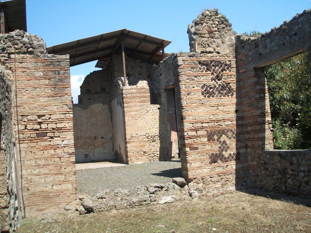 IX.7.20 Pompeii. May 2005. Looking north across atrium to ala or triclinium (room e) from large room (k).
Room (k) was possibly a workshop, with window onto west portico of peristyle.
