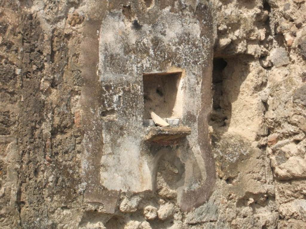 IX.7.21 Pompeii. May 2005. Square niche on west wall of atrium.
According to Boyce, in the north-west corner of the atrium was the hearth. Above the hearth in the west wall was a panel of white stucco. In the panel was a square niche. Its edges were outlined in red against the white background and below it was a cornice. On the reddish coloured back wall of the niche was painted a white object, which Mau was unable to identify. He did state that it was not a phallus. Below the niche was a painted garland of red and green leaves, and below it a burning altar with a pine-cone. On either side of the altar was a yellow serpent. The serpent on the left had a red crest and beard, the head of the other was damaged. See Boyce G. K., 1937. Corpus of the Lararia of Pompeii. Rome: MAAR 14.  (p.88, no.441, and Pl.4, 4) According to Giacobello, the painting is no longer conserved. See Giacobello, F., 2008. Larari Pompeiani: Iconografia e culto dei Lari in ambito domestico.  Milano: LED Edizioni. (p.250)