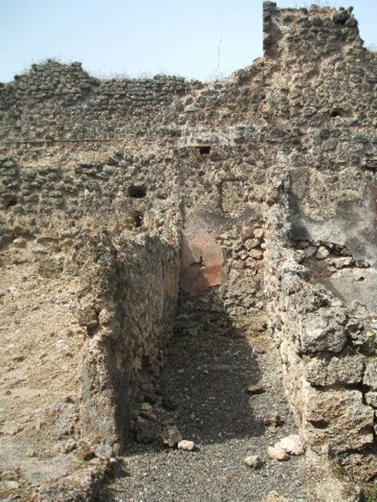 Pompeii. May 2005. Corridor leading to latrine. Looking west. According to Boyce, on the south wall of the passage leading to the latrine was painted the figure of Fortuna. See Boyce G. K., 1937. Corpus of the Lararia of Pompeii. Rome: MAAR 14. (p.88, no.442 and Pl. 26,2)