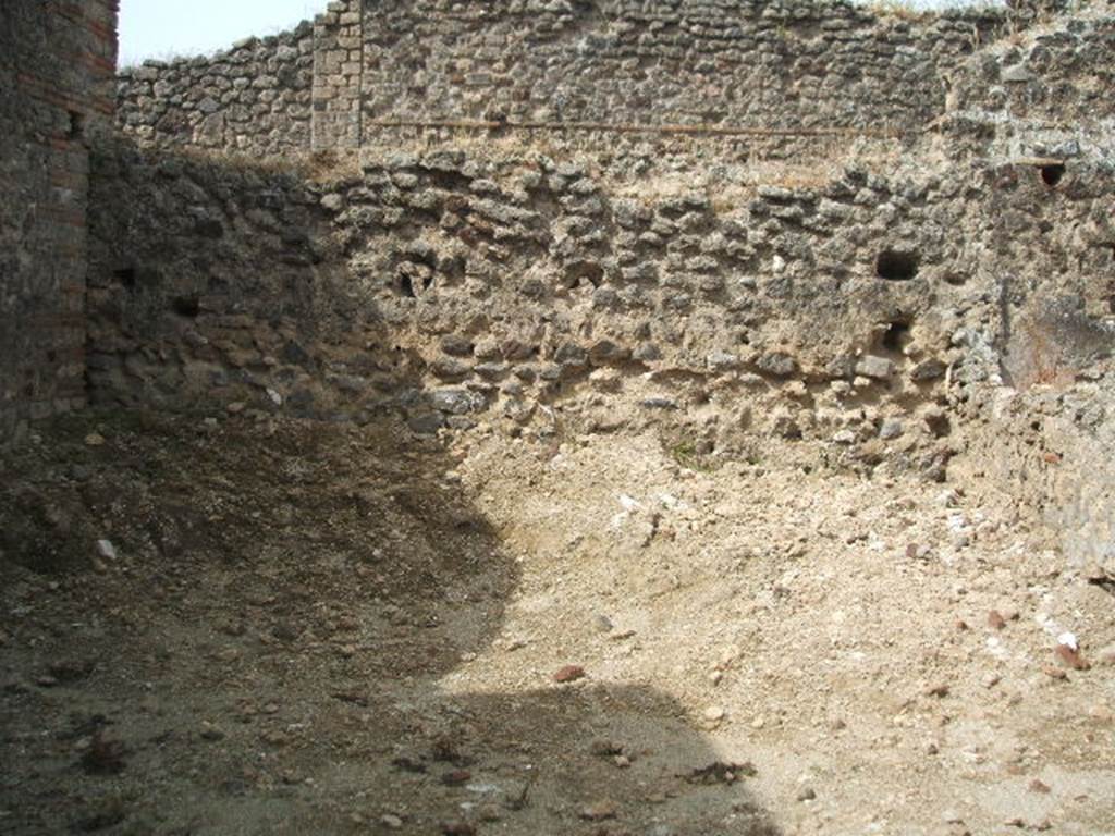 IX.7.21 Pompeii. May 2005. West side of garden area. According to Jashemski, at the rear of the caupona was a small garden area.  Amongst the items found in the garden were 3 feet from a marble table, a monopodium, and, set in the soil, several little mill-stones, and a large terracotta dolium.  See Jashemski, W. F., 1993. The Gardens of Pompeii, Volume II: Appendices. New York: Caratzas. (p.242)