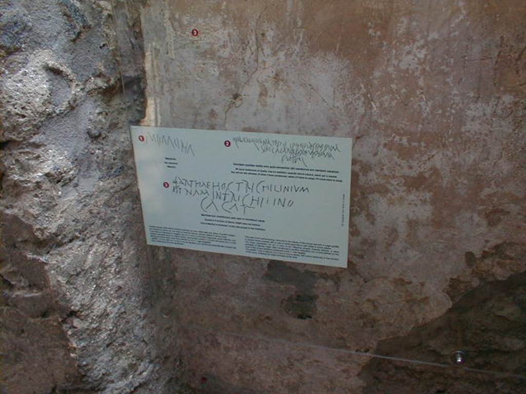IX.8.6 Pompeii. September 2004. Room 27, scratched graffito in plaster on east wall.
Above the printed card (small red numbered 3) would be CIL IV 5244, which was written all across the wall (part also in photo below), reading:
Marthae hoc trichlinium
est nam in trichlinio
cacat  -  (CIL IV 5244)