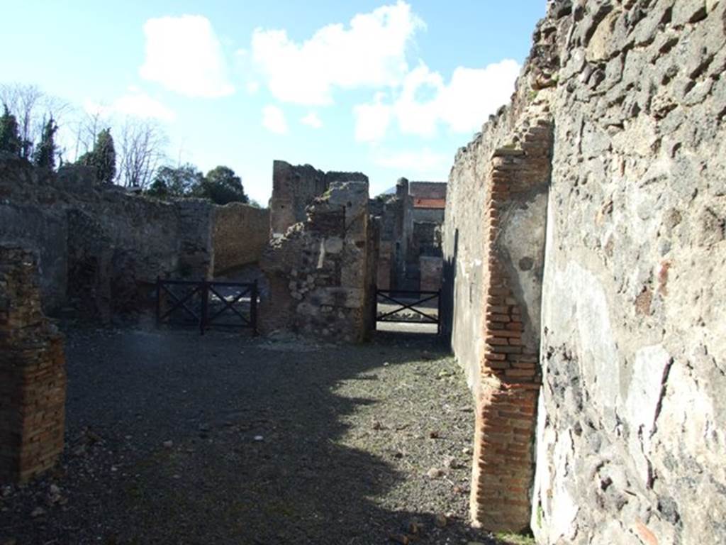 IX.9.2 Pompeii. March 2009.  Looking north from rear, towards thermopolium at IX.9.1 (on left)  and entrance passageway (on right). According to NdS, this would be looking north across the atrium displuviate (atrium without an impluvium). The flooring was made of crushed brick (mattone pesto) and the walls were covered with rustic plaster. Near the west wall was the staircase to the upper floor, made of 13 masonry steps, which was held up by pilasters and arches. Underneath the stairs, these formed three plastered storage recesses or cupboards of different heights. According to NdS, the steps would have been clad with wood on the upper side. In the north-west corner there was a fusorium, or sink. 
See Notizie degli Scavi, 1888, p.514-5
