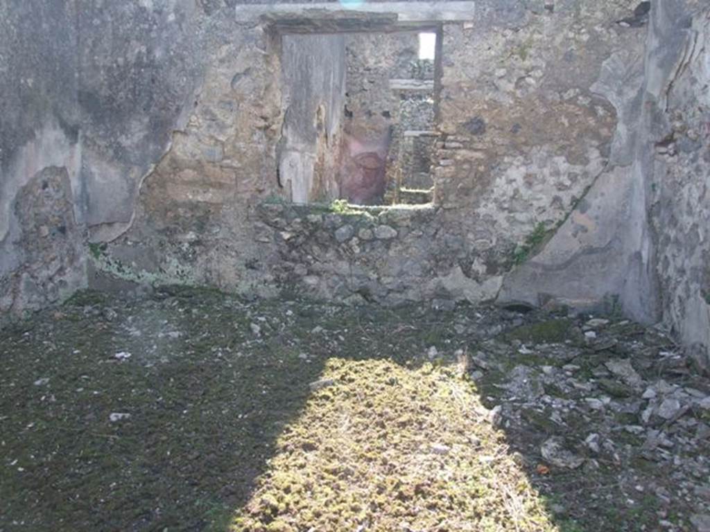 IX.9.12 Pompeii. March 2009. Room 13, triclinium.  Looking west through window into room 16, the light yard of IX.9.e. According to NdS, this room was lit by two windows, there would have been another in the south wall overlooking the garden (on the left). This had another circular window  above it, which would originally have been rectangular. The flooring would have been of crushed brick (mattone pesto), and the walls were decorated with a black background with red bands. In the centre of the north wall (on the right) was a red panel containing a painting which had partly fallen, and the parts which remained had faded. In the south wall near the doorway to the garden area, (see IX.9.13) was a low masonry hearth, which showed the room originally had another use.
See Notizie degli Scavi, 1891, p.257.