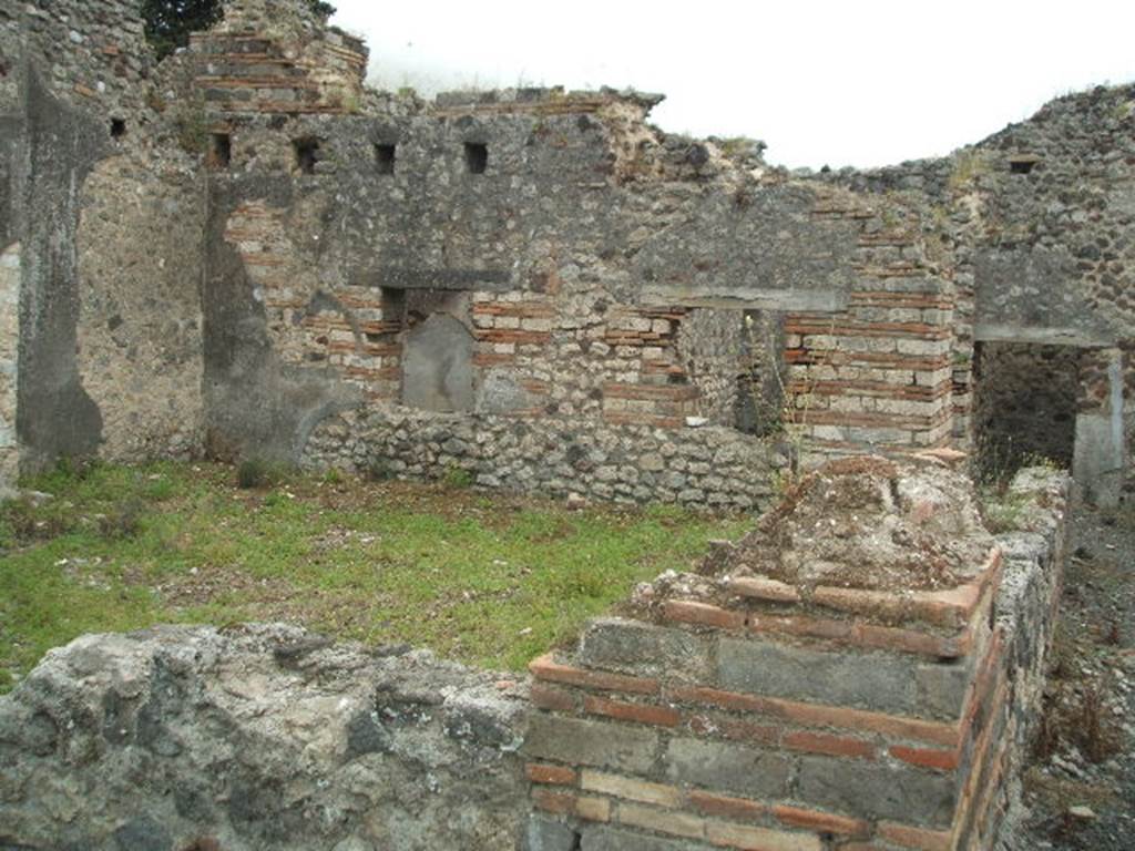 IX.9.a Pompeii. May 2005. Looking south across room “f”, garden from north-west corner.
According to NdS, the peristyle “f” was surrounded by a portico on two sides, the north and west. The portico was supported by plastered brick pilasters, and by one tufa column in the south-west corner. The pilasters were connected by means of a wall between them, and at the base was a channel for rainwater. See Notizie degli Scavi, 1888, p.515.