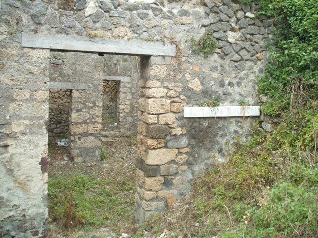 IX.9.g Pompeii. May 2005. Entrance doorway, looking east. According to NdS, this was the doorway to a modest house but had a painting advertising that this was the house of a “painter of electoral programmata”. The doorway led directly into the small atrium which had an attic above, as in the previous house (IX.9.f). The upstairs room had a balcony which jutted out into the roadway, but this had completely fallen when found.
See Notizie degli Scavi, 1891, p.264.
According to NdS, a graffito was found written in charcoal, on the inner surface of the right doorjamb. The doorjamb was faced with yellow painted plaster imitating coloured marble. The graffito showed  -
……… XV| K AVG
XXX XXXV
LXX XV K AVG XL
LXX LX
LXX LX
LXX LX
L.. LX F
LXXX XIIII K aVG LX
LXXXX LX
….. xL xxxC • xLx
According to Sogliano, a drawing found on the right doorjamb showed a male figure in black outline (0.16 high). This was drawn almost from behind his shoulders, stretching his right hand forward, as if in the act of signing something on the wall, and was perceived certainly to be Aemilius Celer, shown in the act of painting slogans on the house-walls of Pompeii. Underneath in black letters, nearly vanished, was the wording - aemiliVS CELER.
See Notizie degli Scavi, 1888, p.520 (recorded as being from IX.7, near the seventh doorway in the side street)