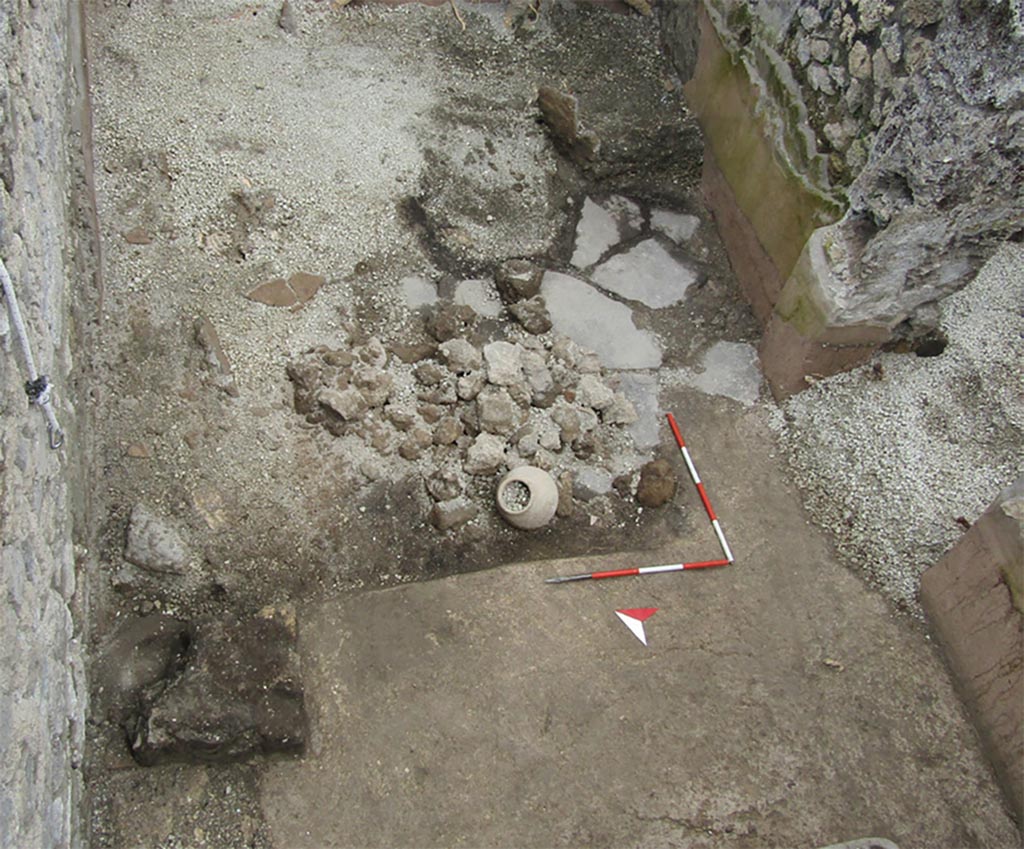 IX.10.1 Pompeii. Floor of bread making room 4.
Starting from the north, we come to room 4, rectangular in shape, divided into two zones: the western one with an opus signinum floor on which masonry elements rest which probably supported tables or cupboards for working bread dough; the eastern one with a paved floor probably intended for grinding grain. A deposit of pumice 0.4 m thick rested on the floor level.
Partendo da nord s’incontra l’ambiente 4, di forma rettangolare, diviso in due zone: quella occidentale con pavimento in cocciopesto su cui poggiano elementi in muratura che sostenevano, probabilmente, tavolati o madie per la lavorazione dell’impasto del pane; quello orientale con pavimento basolato verosimilmente destinato alla macinazione delle granaglie. Sul piano pavimentale poggiava un deposito di pomici spesso 0.4 m.
Photograph © Parco Archeologico di Pompei.
Vedi/See Ri-scavare Pompei: nuovi dati interdisciplinari dagli ambienti indagate a fine ‘800 di Regio IX, 10.1.4. E-journal 2, Scavi di Pompeii, 29.5.2023, p. 3, fig. 2. E-journal on PAP web site