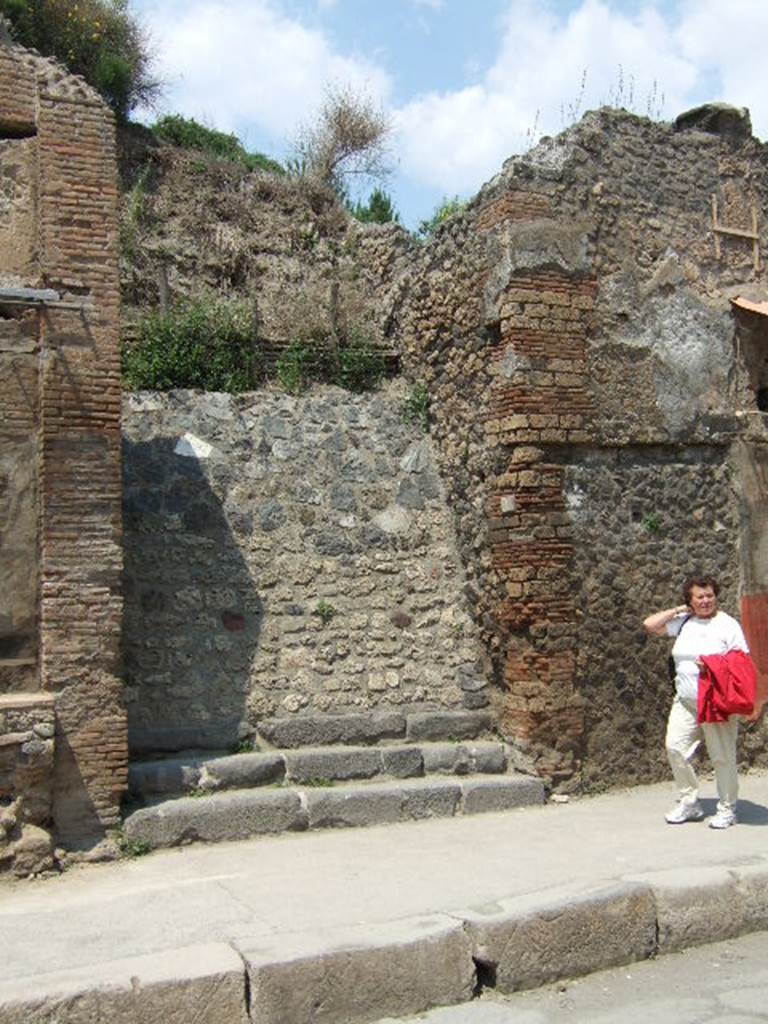 IX.11.1 Pompeii. May 2006.  Entrance doorway, with three steps.
According to Cooley, a graffito was found between IX.11.1 and 2. (See IX.11.2) See Cooley, A. and M.G.L., 2004. Pompeii : A Sourcebook. London : Routledge. (p.123)