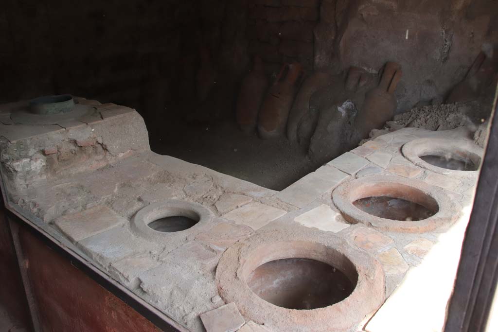 IX.11.2 Pompeii. September 2019. Looking north-east across bar counter with four dolia. Photo courtesy of Klaus Heese.