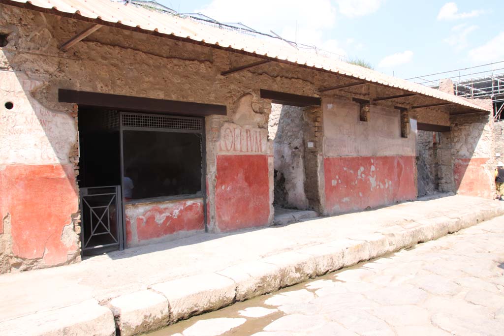 IX.11.2-4 Pompeii. September 2021. 
Looking east along front façade, on north side of Via dell’Abbondanza, with IX.11.2 on left. Photo courtesy of Klaus Heese.