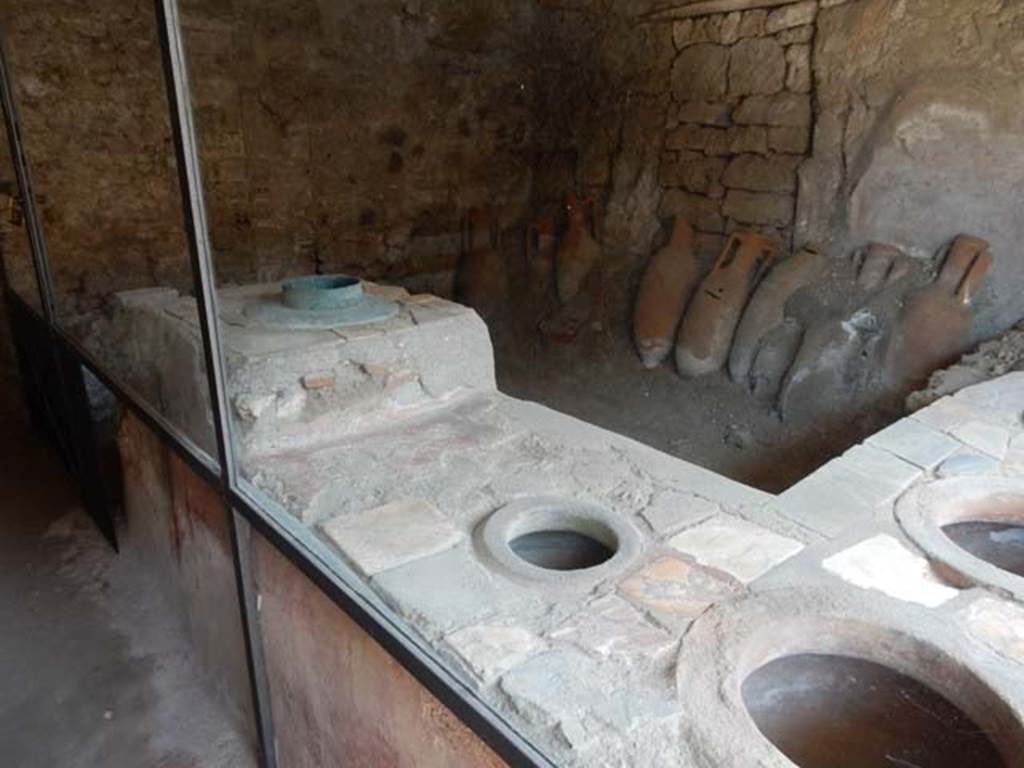 IX.11.2 Pompeii. May 2016. Looking north along counter inset with dolia. At the north end of the bar counter there is a small stove. Photo courtesy of Buzz Ferebee.
