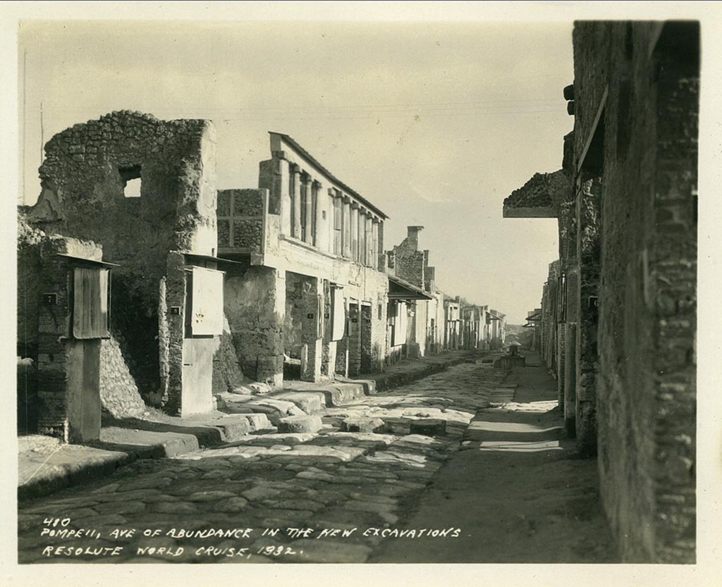 IX.11.8 Pompeii. 1932, looking east on Via dell’ Abbondanza. 
The doorway to IX.11.8 can be seen on the left, between two “protected” graffiti, and with a high, end wall with window. 
Photo taken during a shore-visit from the ship Resolute’s world cruise in 1932. Photo courtesy of Rick Bauer.