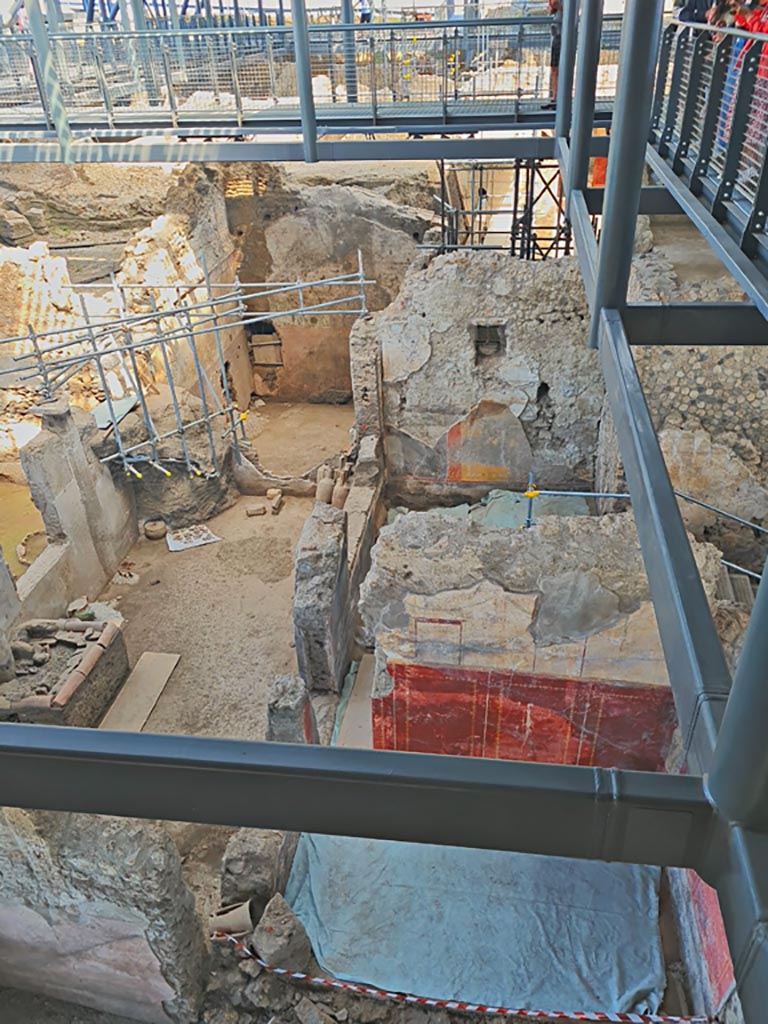 IX.12.4/9 Pompeii. June 2024. Looking north from above IX.12.4. Photo courtesy of Giuseppe Ciaramella.
Room “q” is on the left, with Room “p”, in the upper centre. 
Room “l(L)” is seen on the right with red painted north wall.
On the north side of it, is room “o”, with modern steps (blocked) down into IX.12.6.