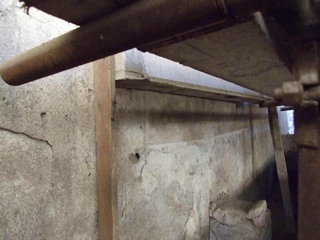 IX.12.6 Pompeii. March 2009. Room “n1”, west wall of internal garden.  
Lararium painting behind boarding, with two painted serpents below. Against the wall is the altar.