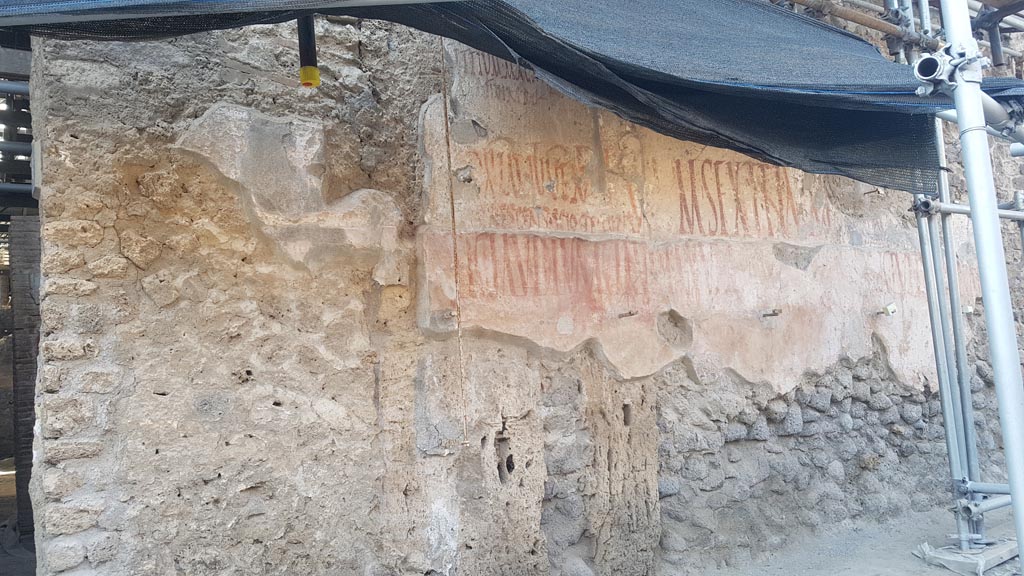 IX.12.6/7 Pompeii. August 2023. 
Graffiti on east side of doorway at IX.12.6, between IX.12.6 and IX.12.7. Photo courtesy of Maribel Velasco.