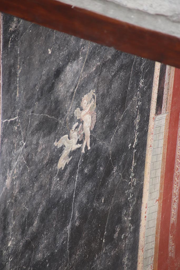 IX.12.A/IX.12.9 Pompeii. October 2024. 
Room 18, north wall, detail of painted Cupid. Photo courtesy of Klaus Heese.