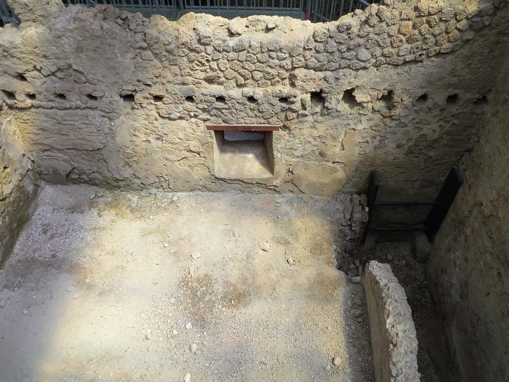 IX.12.B/IX.12.9 Pompeii. May 2010. Room “a”, east wall with window onto vicolo. Not fully excavated. 
Part of the collapsed south wall and the latrine can be seen on the right.
