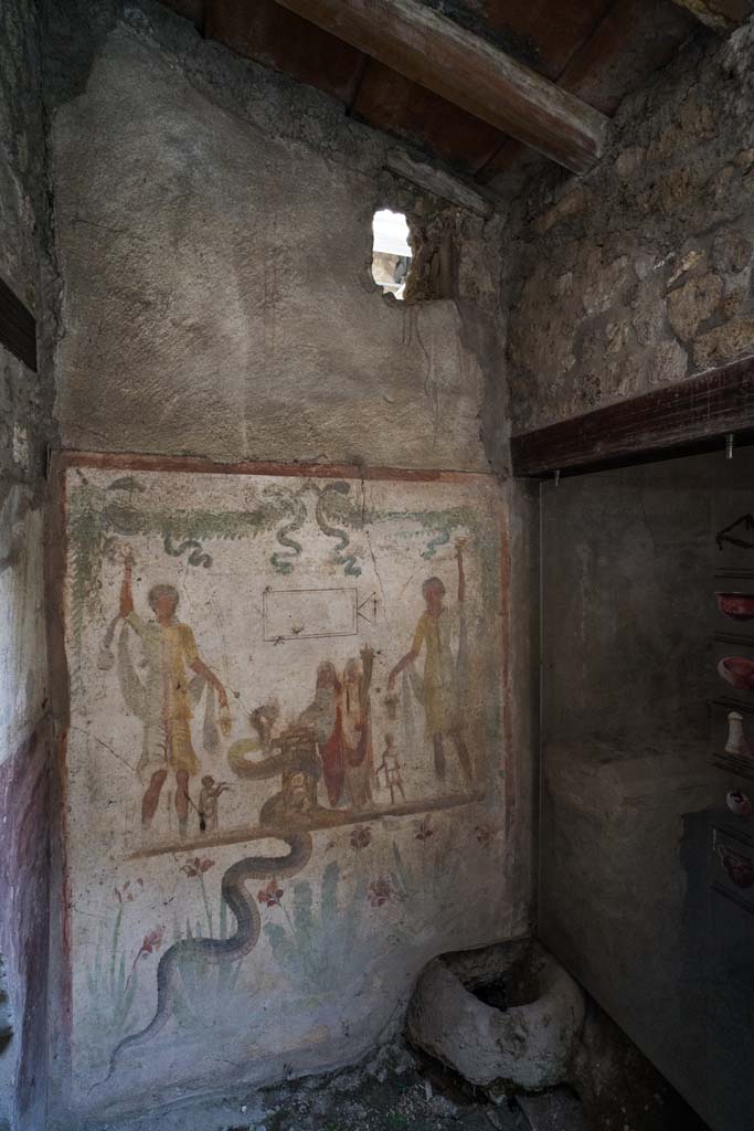 IX.13.1-3 Pompeii. April 2022. 
Room 21, looking towards west wall with lararium in south-west corner. 
Photo courtesy of Johannes Eber.
