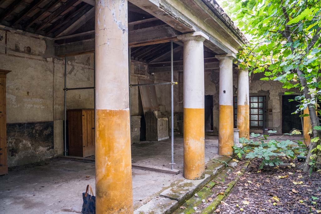 IX.13.1-3 Pompeii. October 2021. 
Room 9, looking south-east along east portico, with plaster casts and reproduction cupboards. Photo courtesy of Johannes Eber.