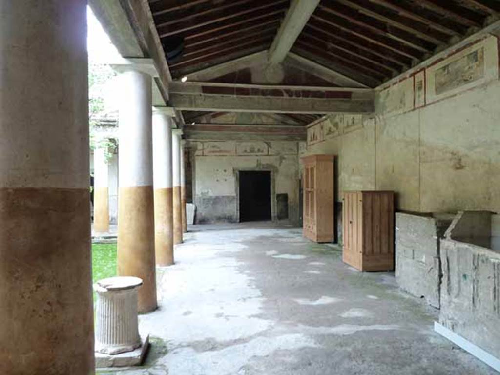 IX.13.1-3 Pompeii. May 2010. 
Room 9, looking north along east portico with plaster-casts and reproduction wooden cupboards, on right.