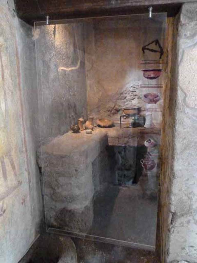 IX.13.1-3 Pompeii. May 2010. Room 23, kitchen, with cooking utensils on hearth.