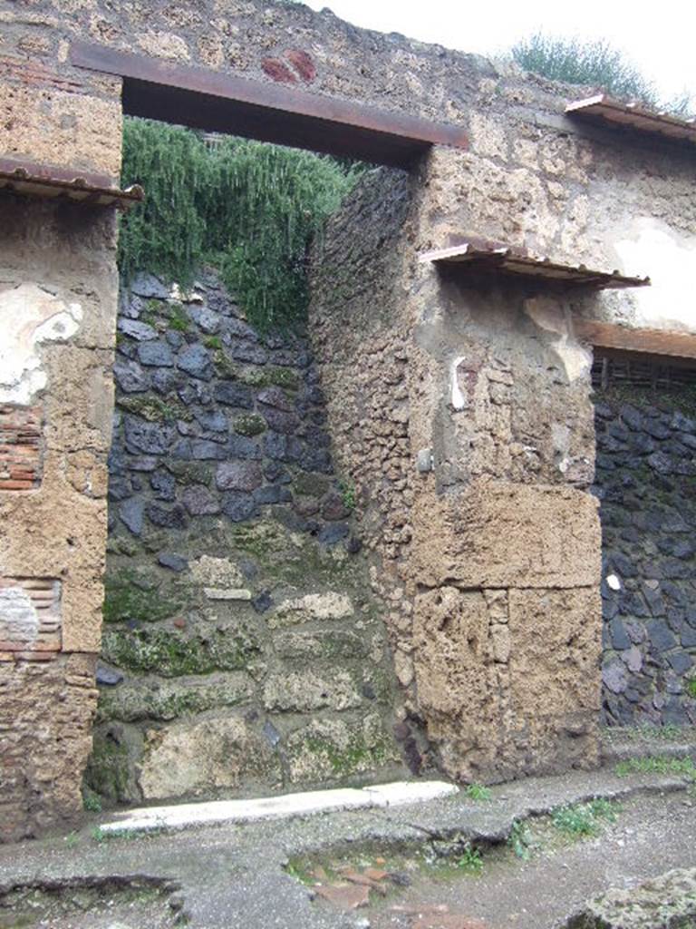 IX.13.5 Pompeii.December 2005. Entrance doorway.  There was a small painting on either side of the doorway.   These were surrounded by the chessboard decoration still visible at IX.13.6.  Aeneas was on the right hand side of the door and Romulus on the left. See Fröhlich, T., 1991, Lararien und Fassadenbilder in den Vesuvstädten.  Mainz: von Zabern.  (F72, p.339/40).