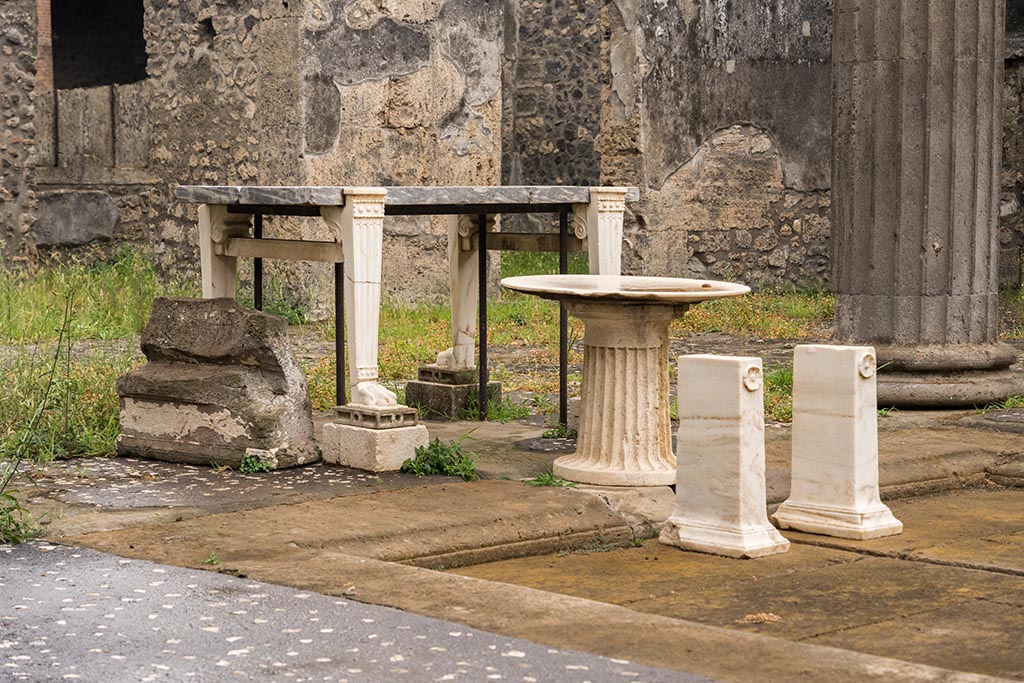 IX.14.4 Pompeii. July 2024. 
Looking south-west towards items on south side of impluvium, from east side. Photo courtesy of Johannes Eber.