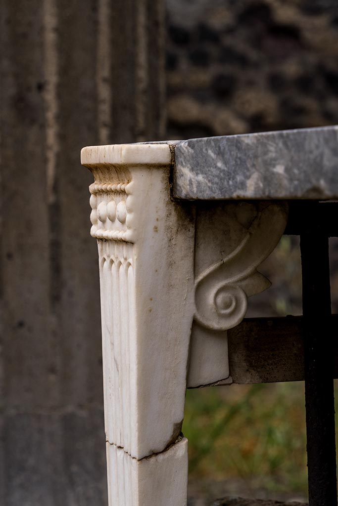IX.14.4 Pompeii. July 2024. 
Detail of front table leg on east side of table. Photo courtesy of Johannes Eber.