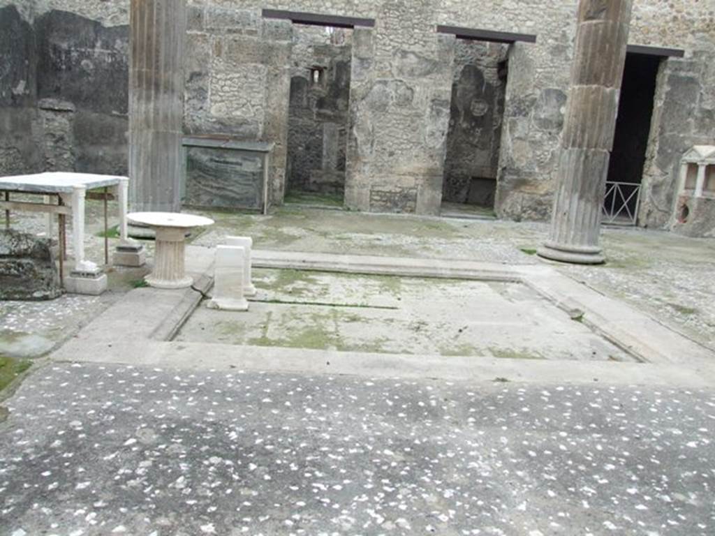 IX.14.4 Pompeii. December 2007. West side of the atrium B with lararium shrine 32, on the right. Looking across the impluvium to the tall doorways of rooms 26, 30 and 31 after restoration.