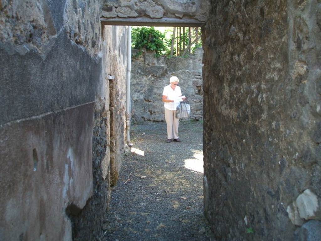 IX.14.4 Pompeii. May 2005. Looking south through corridor (r) to rustic area with doorway to room 6 on the left.