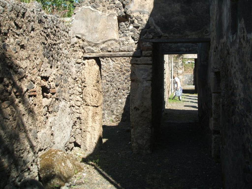 IX.14.4 Pompeii.   May 2005.  Looking north through corridor in south west corner of house.  
The doorway to room 11 is on the left.
