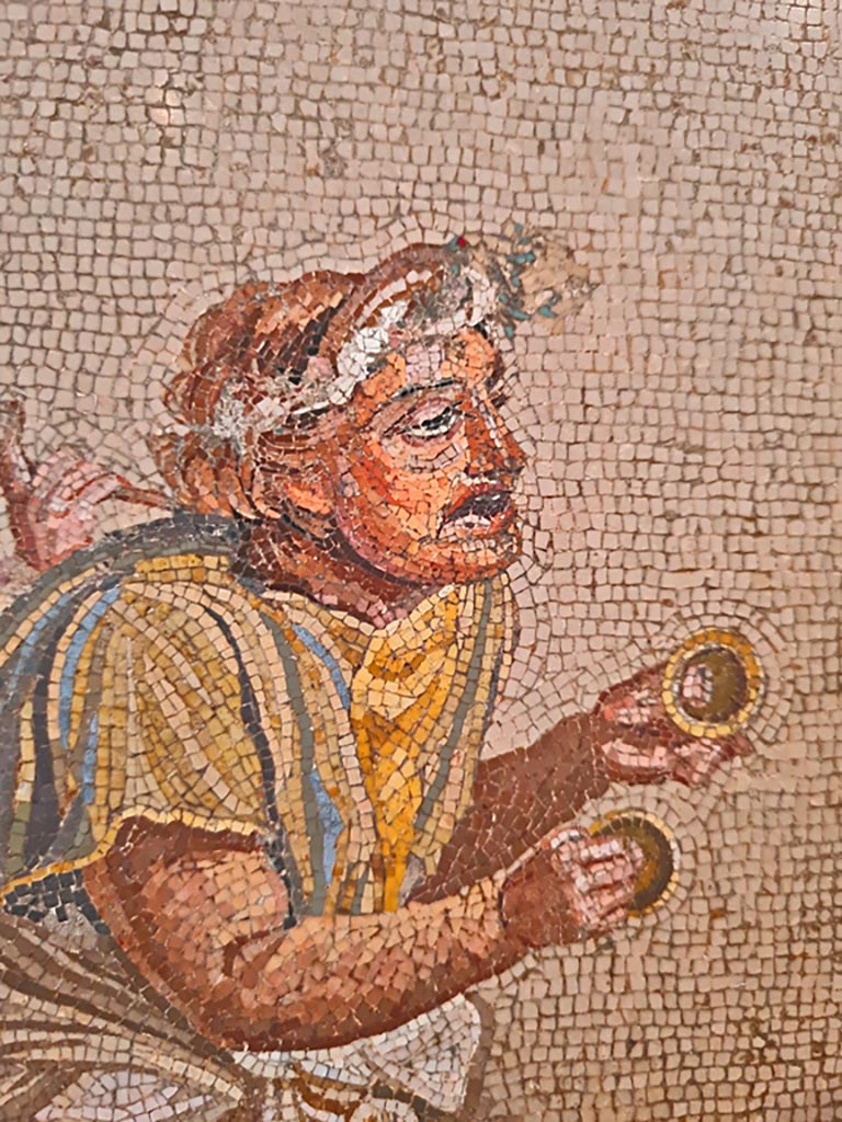 HGW06 Pompeii. Found on 8th April 1763. Ambiente 13 of Villa of Cicero. 
Detail from mosaic of a Group of Street Musicians showing a musician playing cymbals. 
Now in Naples Archaeological Museum. Inventory number 9985.
Photo courtesy of Giuseppe Ciaramella. September 2024.