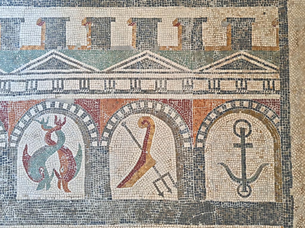 Villa of Diomedes ? or VI 17.10 Pompeii ?. June 2024.  
Detail from mosaic of “doors”, starting with two dolphins, a trident and an anchor.  
On display in Naples Archaeological Museum, Room CXXXIV.  Photo courtesy of Giuseppe Ciaramella.