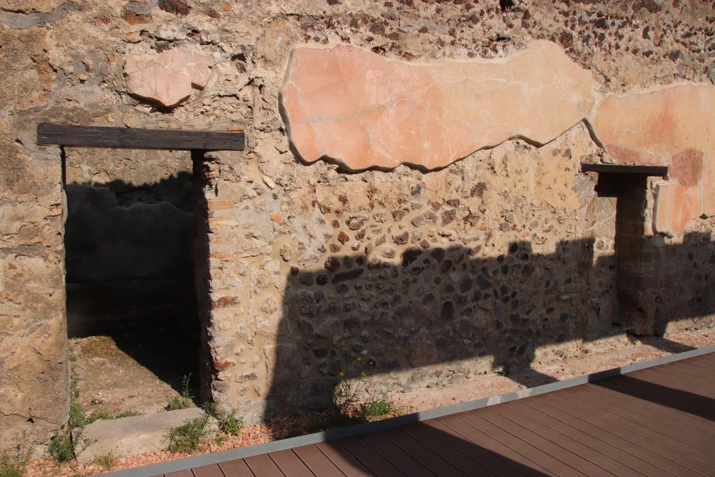 HGW24 Pompeii. Villa of Diomedes. October 2023. 
North wall of peristyle with doorway leading into rooms, on left, and niche, on right. Photo courtesy of Klaus Heese.
(Fontaine doorway to room 2,1, leading into room 2,2, on left).