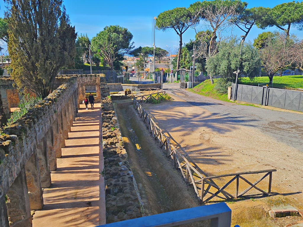 HGW24 Pompeii. Villa of Diomedes. March 2024. Looking south along north portico, on left, from upper terrace. 
The area of the original carriage entrance to Pompeii in the 1800’s, can be seen on the right. Photo courtesy of Giuseppe Ciaramella.