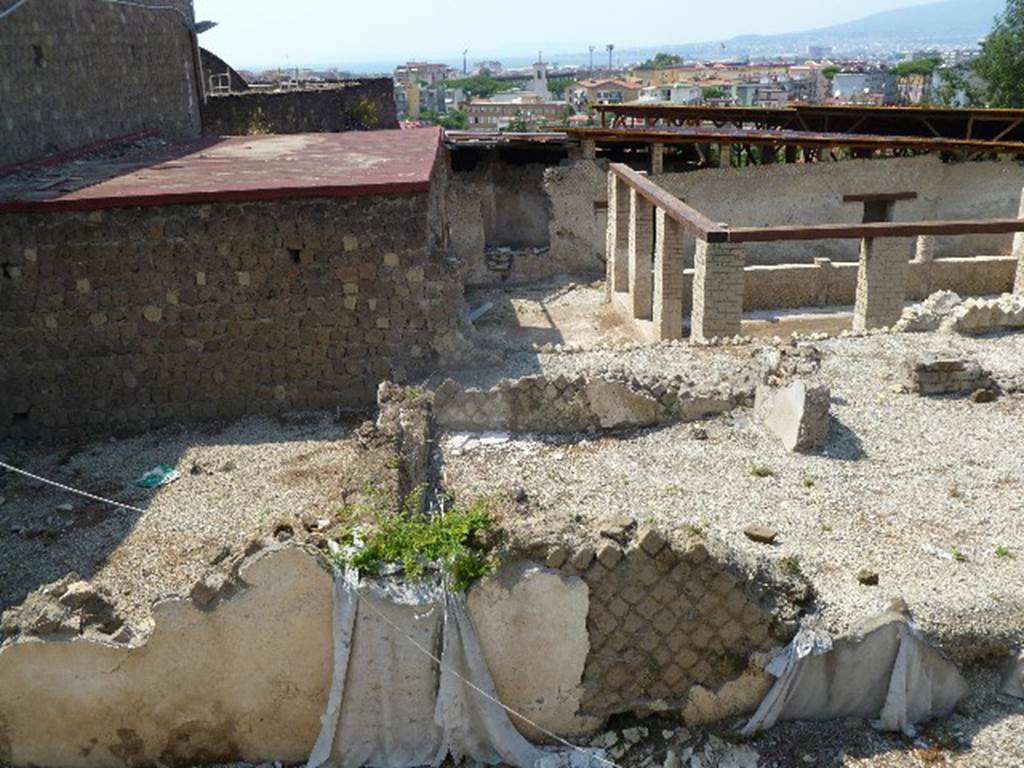 Villa San Marco, Stabiae, July 2010. Looking north. Photo courtesy of Michael Binns.
According to the descriptive information card –
“The latest archaeological researches have brought to light some of the northern (we describe as eastern) structures next to the atrium of Villa San Marco.
These structures have been partially known by the drawings made during the Bourbon excavations. 
It is a sort of a trapezoidal peristyle directly linked to the tablinum of the villa. 
The inner part of the peristyle was arranged as a garden with a large central tree.
On the north wing (we say east side) a monumental entrance, distinguished by two side semi-columns, is widely opened to the public way. 
On the left it is possible to see a small room made by hurdle, probably used by the slave who served as doorkeeper.
On the west side (we describe as north side) two triangular rooms used as lavatories have been dug, in which several graffiti have been found.
Along the eastern front (we describe as the south side), there are a series of rooms, probably used as servants’ quarters or as food storage, while in the north-west wing (we describe as the north-east corner) a brick staircase was used to connect the ground floor with the first floor of the house.”
According to Keppie, this is a peristyle garden which would have been on the east of the atrium and tablinum.
Some elements originally exposed in the eighteenth century are being gradually opened up again.
See Keppie, L. (2009). The Romans on the Bay of Naples: an archaeological guide. The History Press, Stroud, Glos. (p. 148-9).
See Terpstra T, The 2011 Field season preliminary Report at http://www.fastionline.org/docs/FOLDER-it-2012-259.pdf