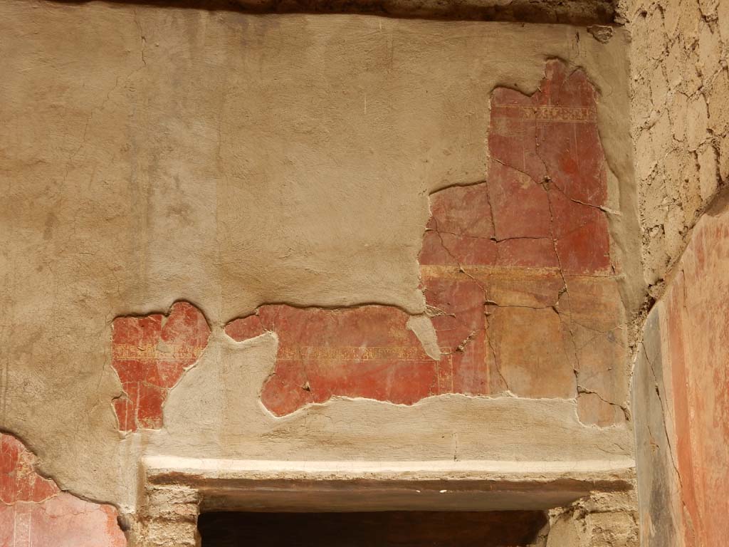 Villa San Marco, Stabiae, June 2019. Room  25, detail of painted decoration above doorway in west wall in north-west corner.
Photo courtesy of Buzz Ferebee
