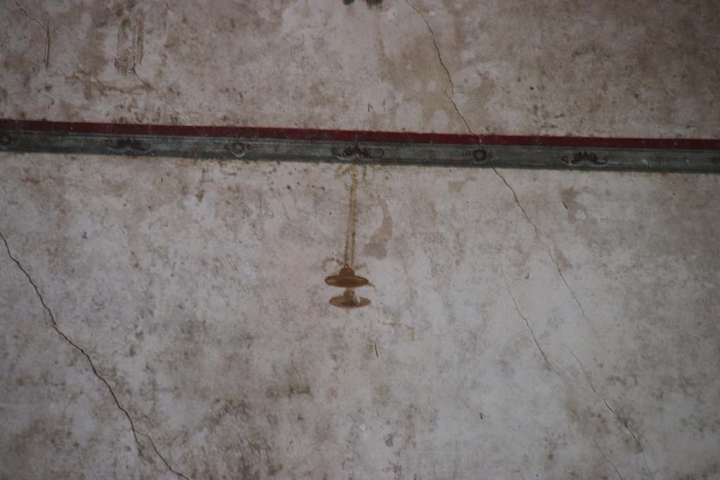 Villa of Mysteries, Pompeii. September 2021. 
Room 11, detail of painted decoration under mask in centre of upper south wall. Photo courtesy of Klaus Heese.