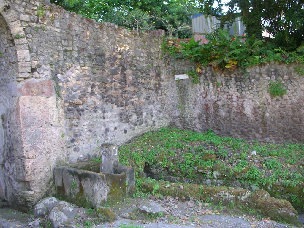 Via Stabiana, west side, Pompeii. May 2010. 
Looking towards north-west side of gate, with fountain and course of drain. Photo courtesy of Ivo van der Graaff.