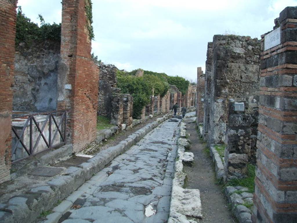 Via degli Augustali between VII.2 and VII.12. December 2004.Looking east from crossroads, outside of VII.12.1.